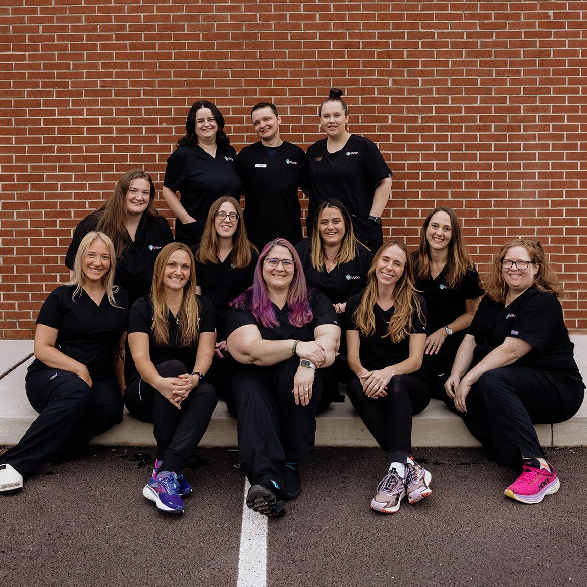 United Vision Pet Partners Team outside against brick wall